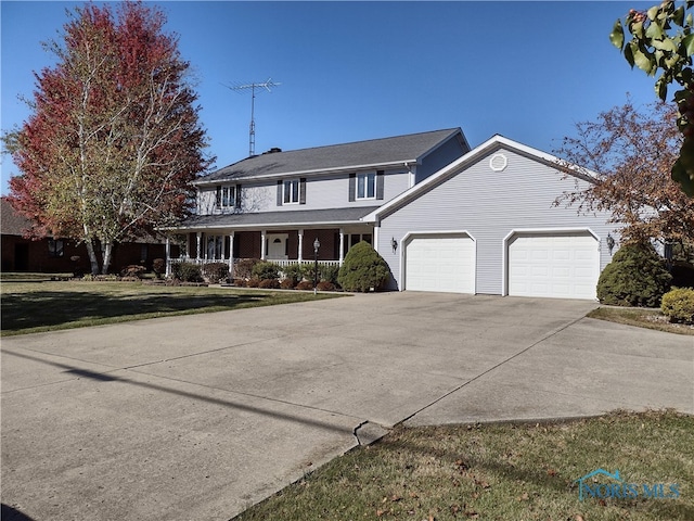 view of front of property featuring a garage, a front lawn, and a porch