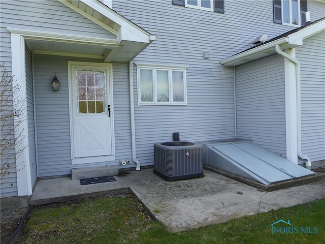 view of exterior entry featuring central AC unit