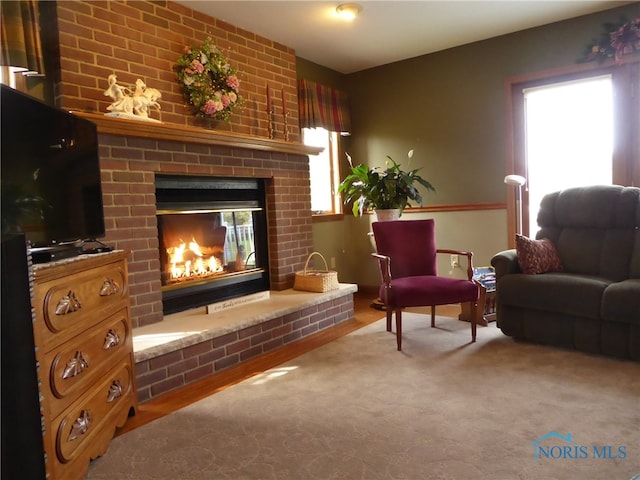 sitting room featuring carpet floors and a brick fireplace