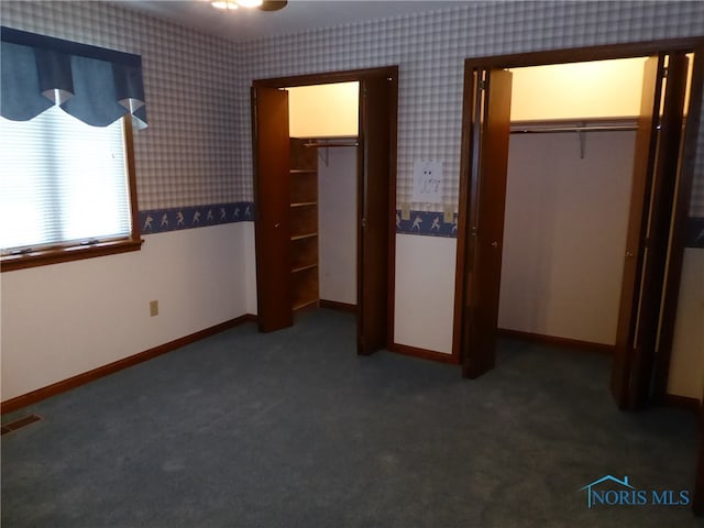 unfurnished bedroom featuring a closet and dark carpet