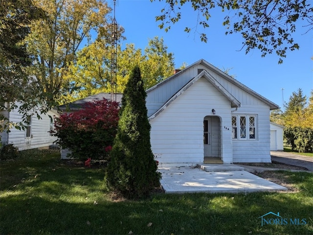 back of house with a patio area and a lawn