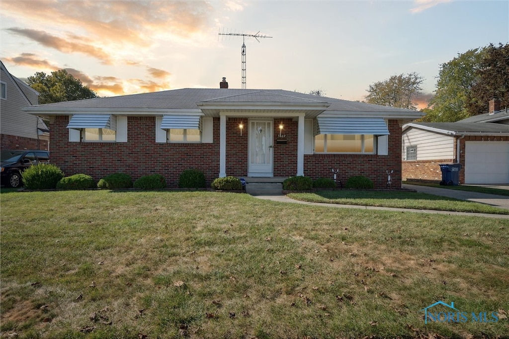 single story home featuring a lawn