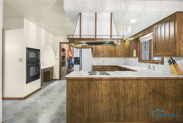 kitchen featuring black appliances, sink, and kitchen peninsula