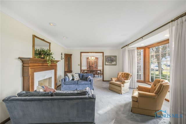 carpeted living room featuring a chandelier, crown molding, and a fireplace