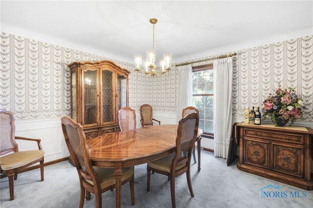 carpeted dining space featuring a notable chandelier