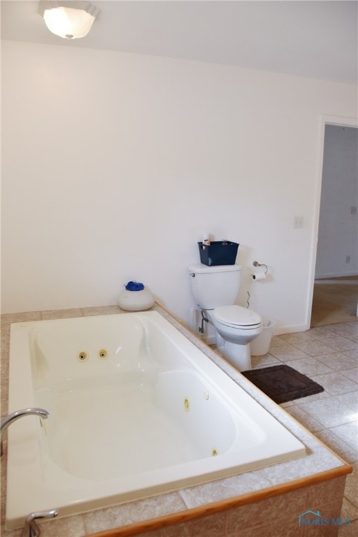 bathroom with a relaxing tiled tub, tile patterned floors, and toilet