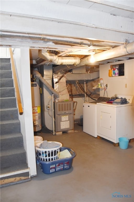 basement with gas water heater, heating unit, and independent washer and dryer