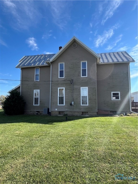 rear view of property with a yard and central AC