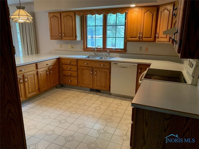 kitchen with kitchen peninsula, decorative light fixtures, sink, and white appliances