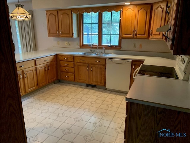 kitchen featuring white appliances, sink, kitchen peninsula, and decorative light fixtures