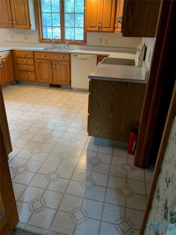 kitchen featuring dishwasher, sink, and range