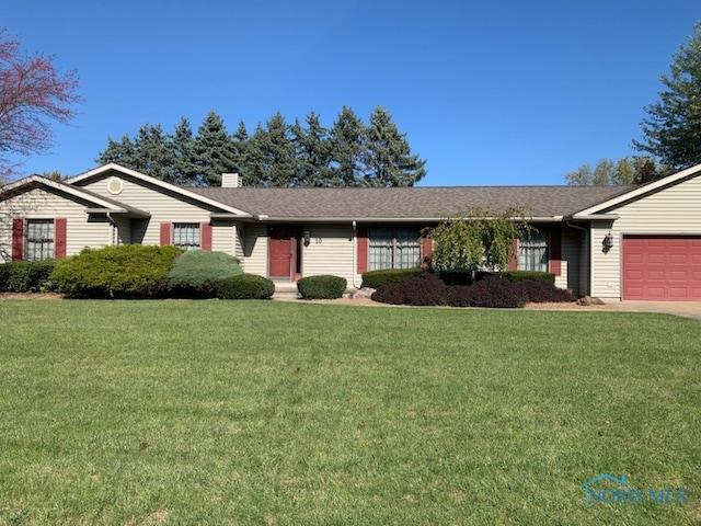 ranch-style home featuring a garage and a front lawn