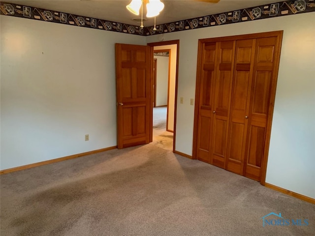 unfurnished bedroom featuring light colored carpet, a closet, and ceiling fan