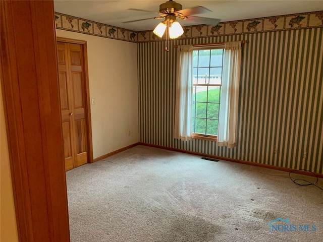 carpeted spare room with ceiling fan