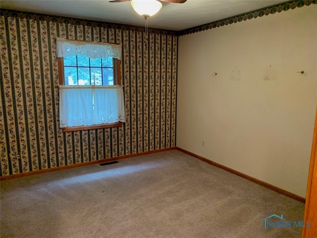 empty room featuring carpet flooring and ceiling fan