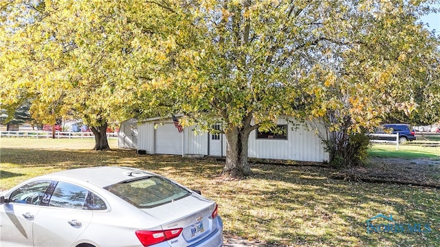 view of front of house featuring a garage, an outdoor structure, and a front yard