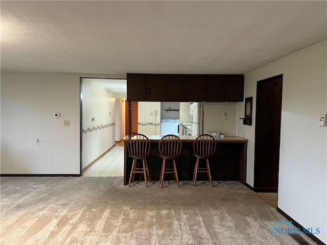 carpeted dining room featuring a textured ceiling