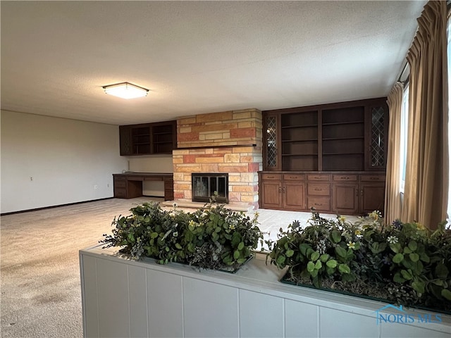 carpeted living room with a fireplace and a textured ceiling