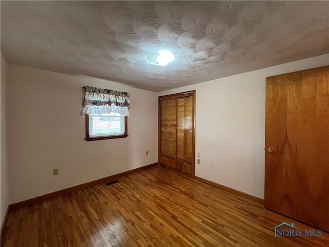 empty room with hardwood / wood-style flooring