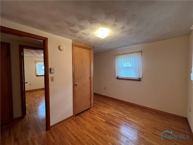 spare room featuring a wealth of natural light and light hardwood / wood-style flooring