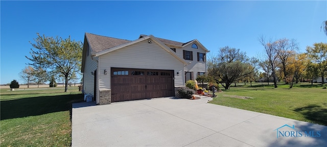 view of side of property with a yard and a garage