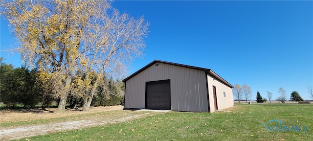 view of outbuilding featuring a garage and a lawn