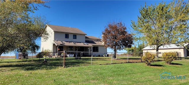 rear view of property featuring a lawn