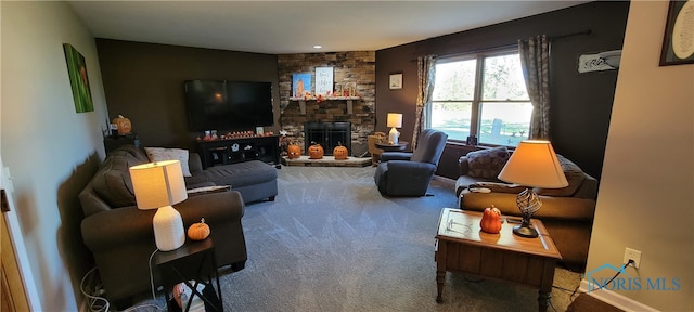 carpeted living room with a stone fireplace