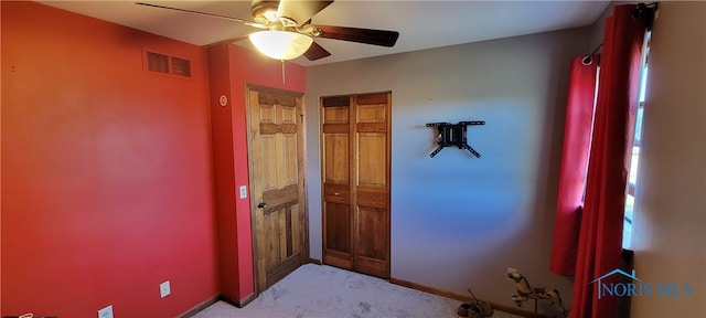 unfurnished bedroom featuring light carpet and ceiling fan