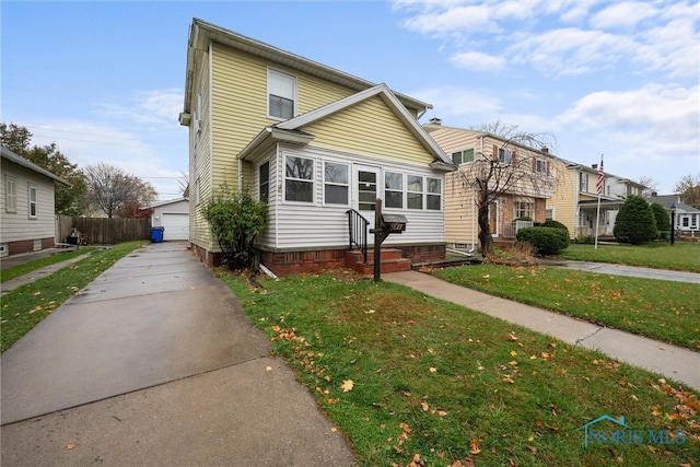 front facade with a garage, a front lawn, and an outdoor structure