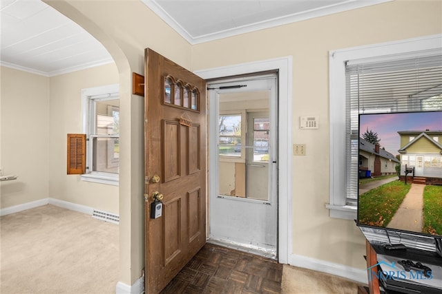 foyer entrance featuring crown molding and dark parquet floors