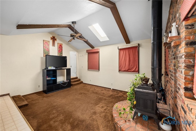 carpeted living room with a wood stove, lofted ceiling with skylight, and ceiling fan