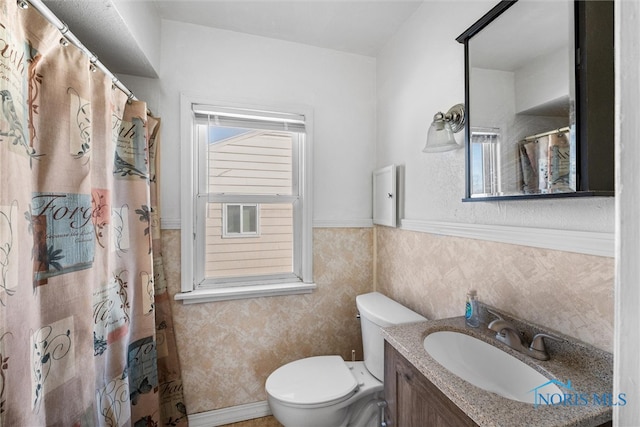 bathroom with vanity, tile walls, and toilet