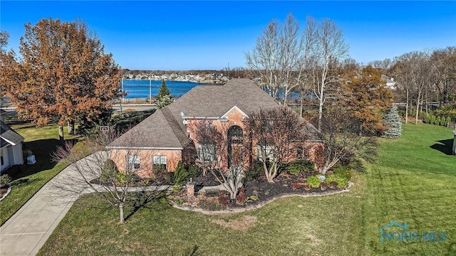 view of front of house featuring a shingled roof and a front yard