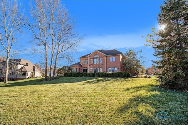 view of front of home featuring a front lawn and brick siding