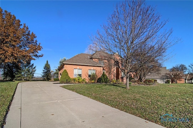 view of front of home featuring a front lawn and brick siding