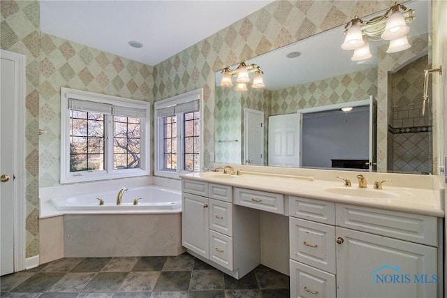 bathroom with double vanity, wallpapered walls, a sink, and a bath