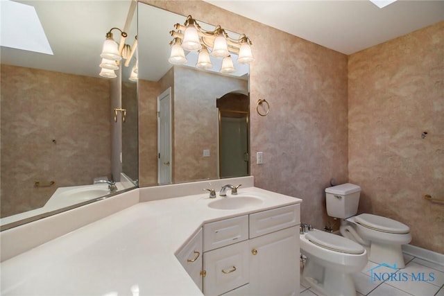 full bathroom with a skylight, toilet, a bidet, vanity, and tile patterned flooring