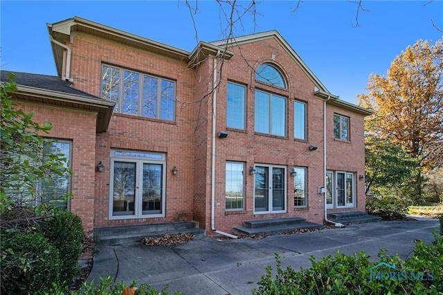 rear view of house with entry steps and brick siding