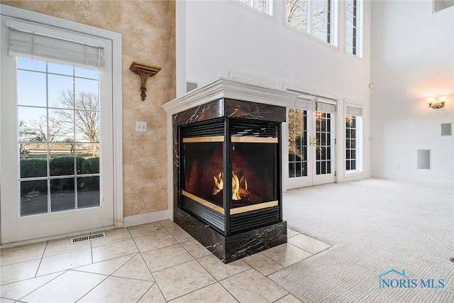 details featuring carpet floors, a premium fireplace, visible vents, and baseboards