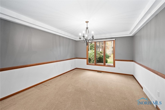 unfurnished room featuring carpet floors and a notable chandelier