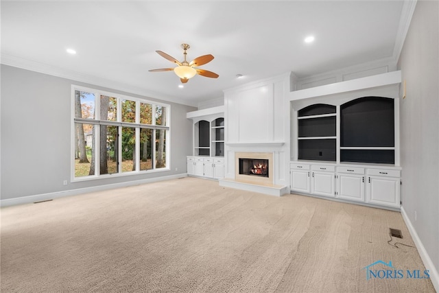 unfurnished living room with light colored carpet, ceiling fan, and ornamental molding