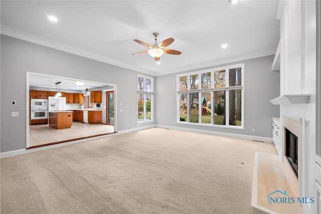 unfurnished living room with ceiling fan, light carpet, and ornamental molding