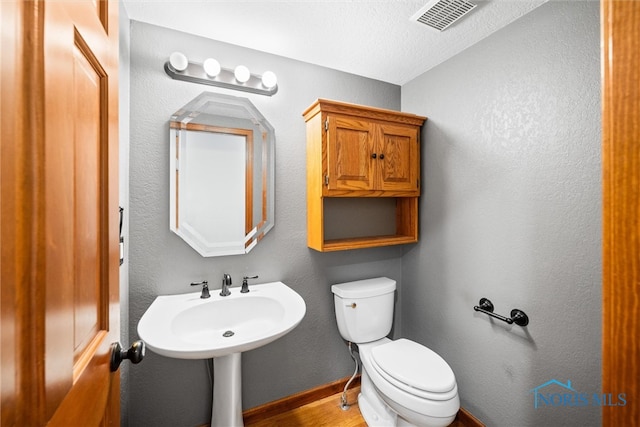 bathroom with a textured ceiling and toilet