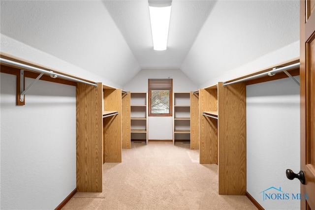 spacious closet featuring light colored carpet and vaulted ceiling