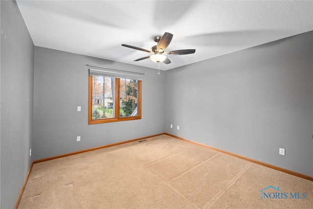 carpeted spare room featuring ceiling fan