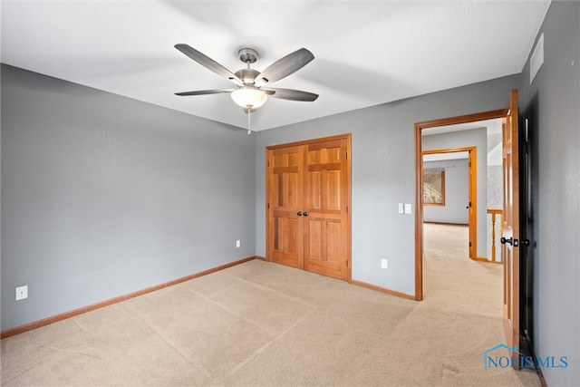 unfurnished bedroom with a closet, light carpet, and ceiling fan