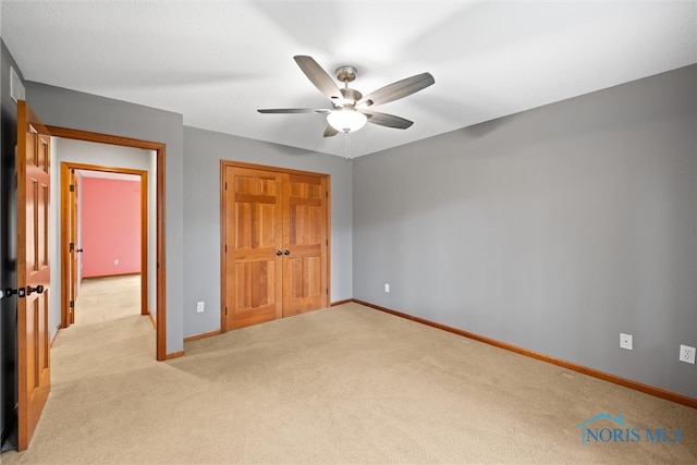 unfurnished bedroom with ceiling fan, a closet, and light colored carpet