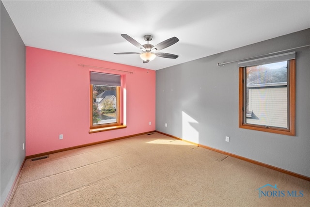 carpeted spare room featuring ceiling fan