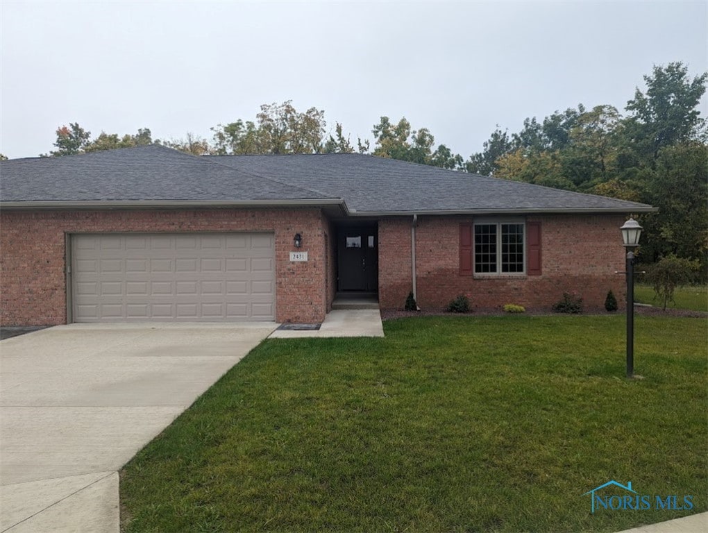 ranch-style house featuring a front lawn and a garage